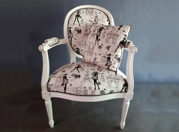 Fauteuil ancien retapissé d’un tissu à motifs rétro dans l’atelier près de Rambouillet